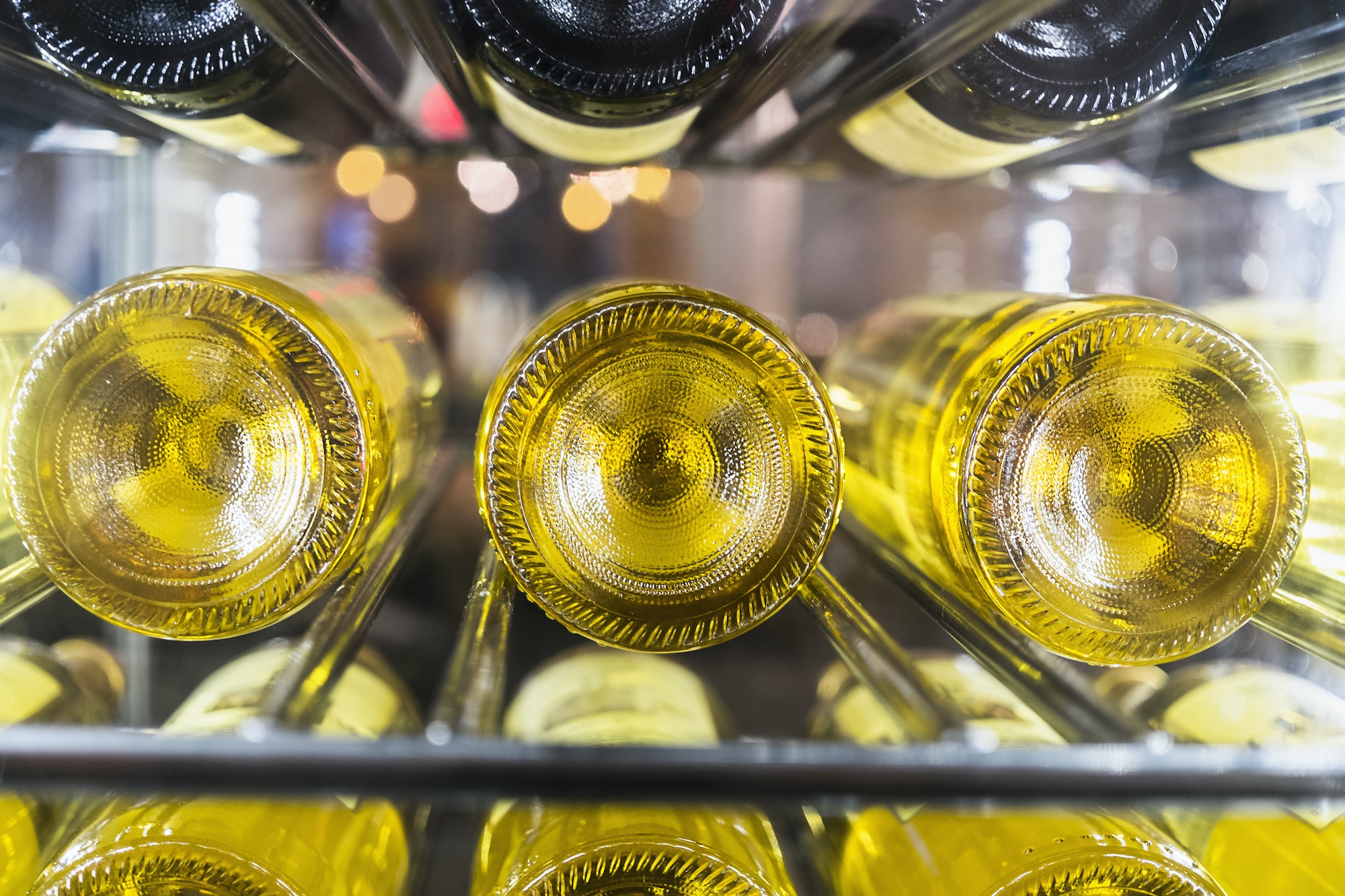 View of bottles of white wine laid down on a rack in a cellar.